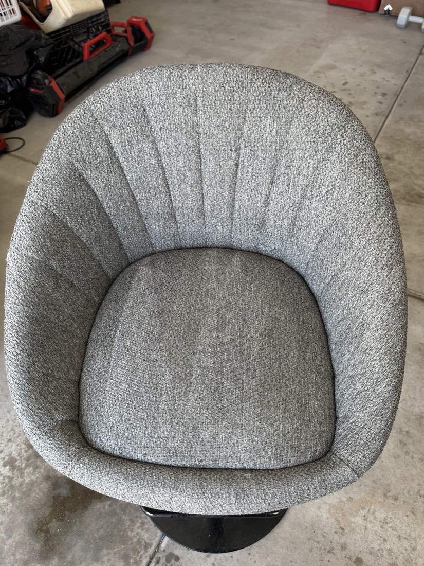 A grey upholstered swivel chair