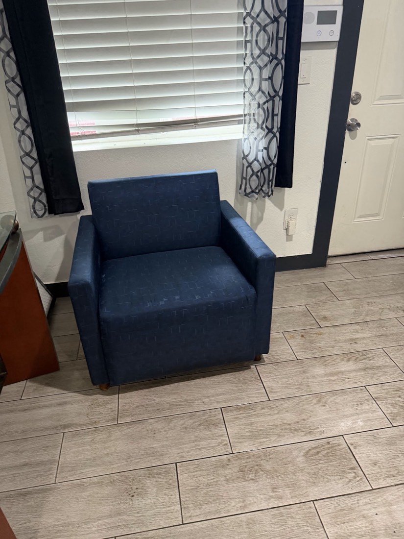 A navy armchair cleaned on a tile floor
